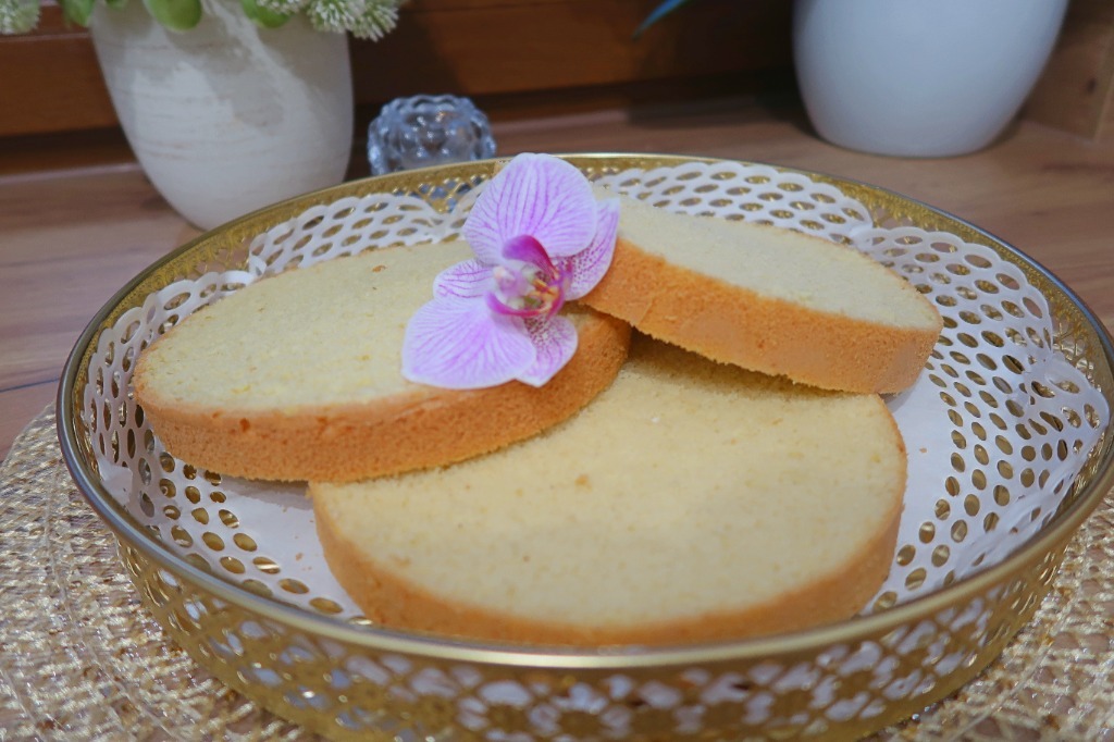 Świeżo upieczone biszkopty na złotej tacy z orchideą